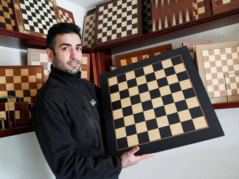 David Ferrer poses with a chessboard at the Rechapados Ferrer factory.