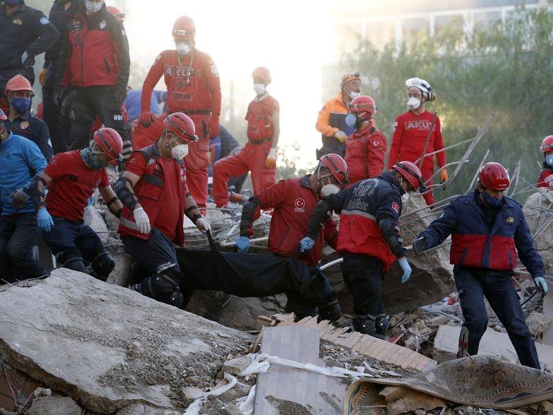 Rescue services carry the body of a child from the debris of a quake-destroyed building in Izmir.