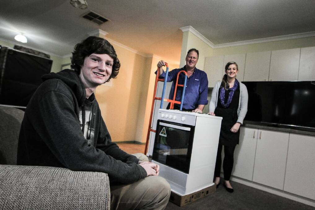 Ashley Lewis relaxes as Bing Lee Wodonga store manager Anthony Cowan and Junction Support Services’ Katharine Hodgens arrive with a new stove. Picture: DYLAN ROBINSON
