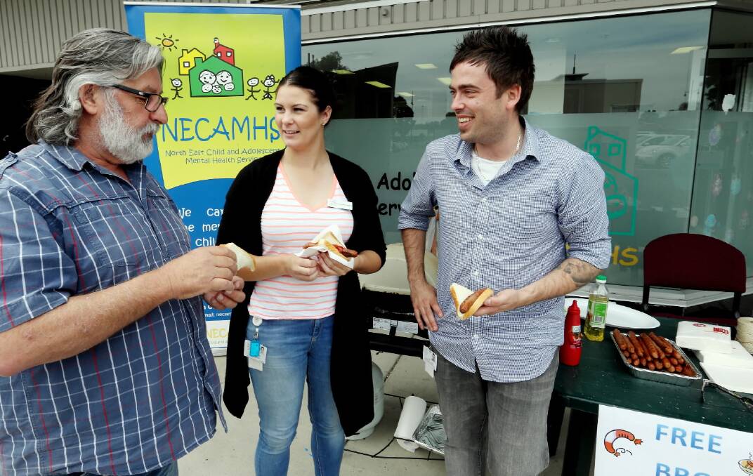 Wodonga NECAMHS program manager Terry Scanlan talks to social worker Gemma Coburn and social work student Carl Rogalski at their free barbecue yesterday. Picture: PETER MERKESTEYN