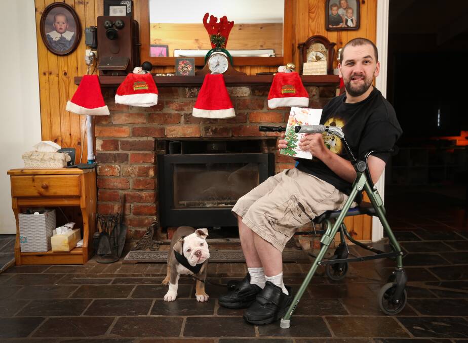 DREAM COME TRUE: Callum Clegg, 28, with dog Jack and his first published book, My Christmas Tales. He will be signing copies at 10.30am Saturday in Dymocks Albury. Picture: KYLIE ESLER 