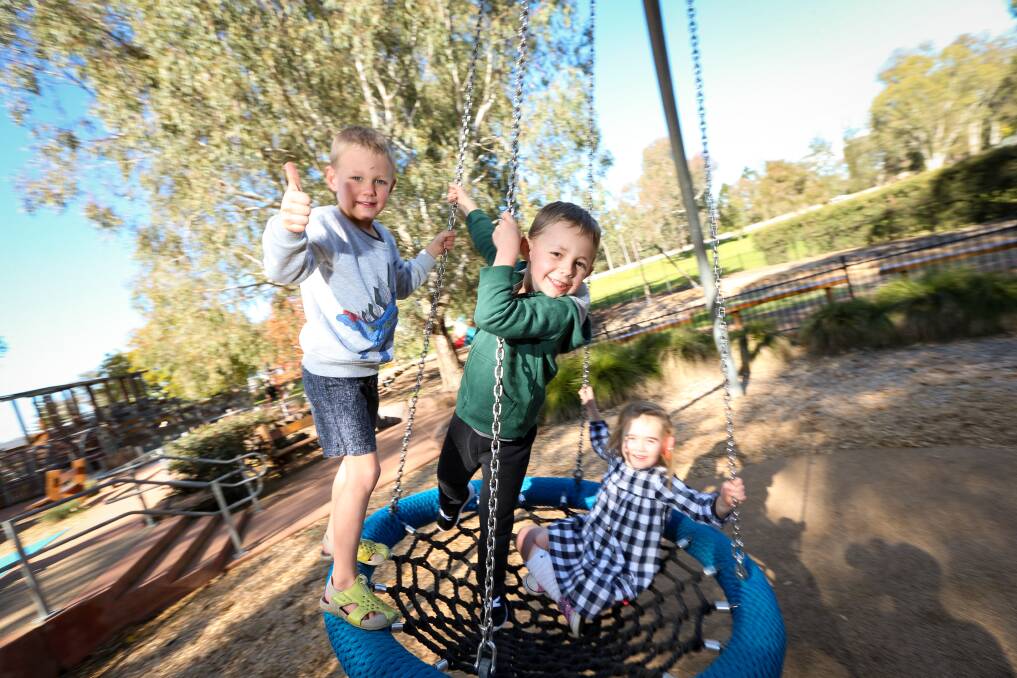 SWING BACK TO LIFE: : Willis Hogg, 5, and Xander Cochrane, 6, and Anika Pickett, 4 at Oddies Creek Park on Friday enjoying a return to normal play. Picture: JAMES WILTSHIRE 