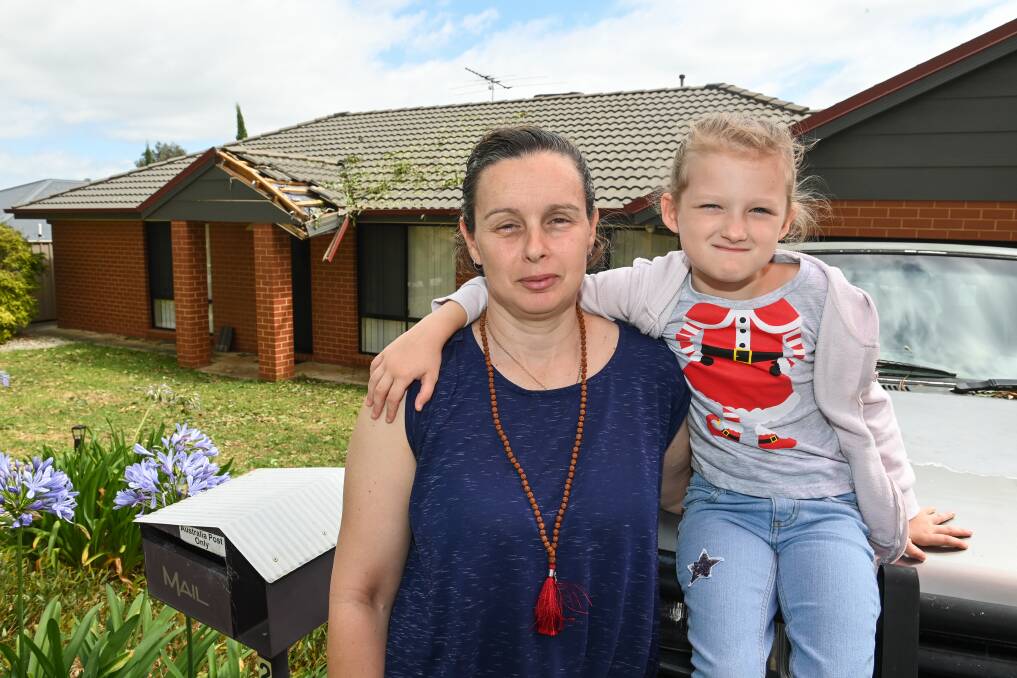 FRIGHTENING: Wodonga's Rachael Fletcher with daughter Leilah, 7 in front of their damaged Streets Road home. 