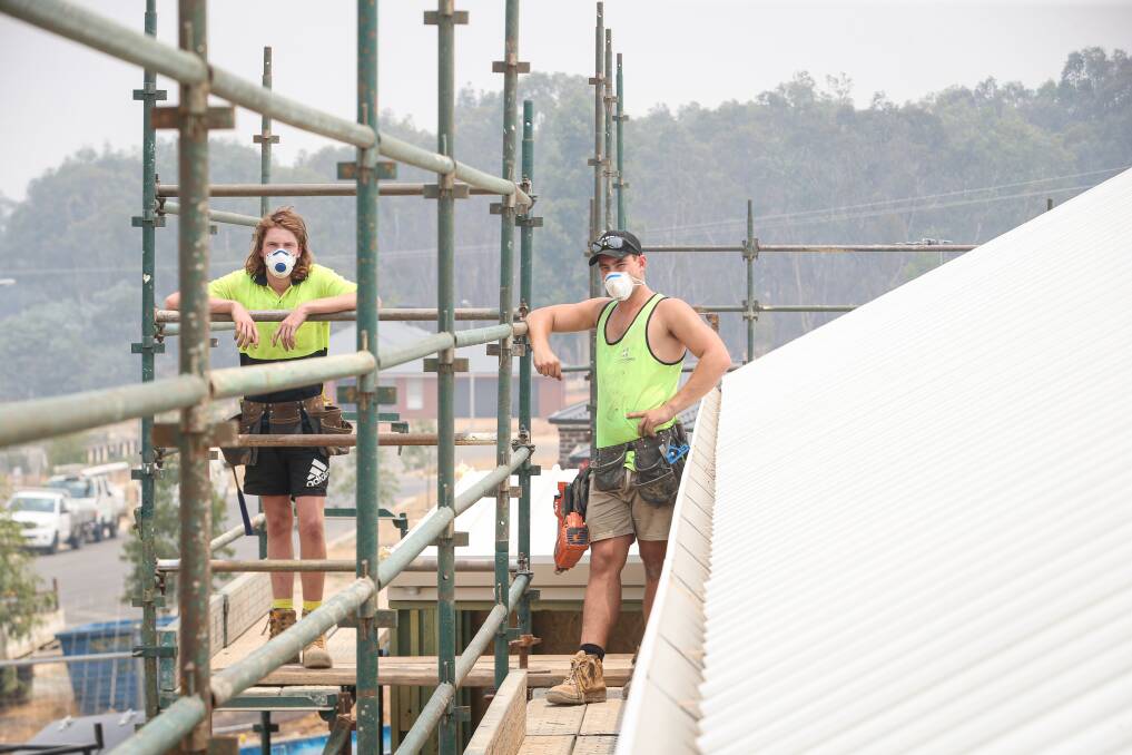PREPARED: Cohen Homes' Lachlan Brodie and Lachlan Lowe aren't worried about working in the smoke but have masks on hand if needed. Picture: JAMES WILTSHIRE