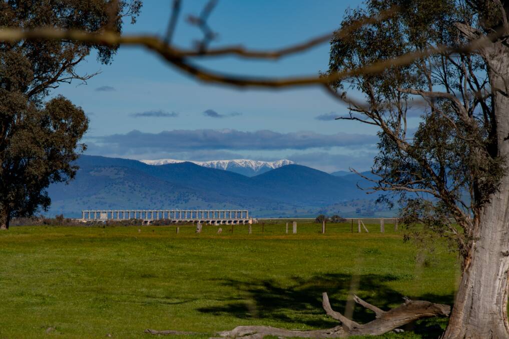 CHILL AFTERNOON: A view of the Hume Dam with snow-capped mountains in the background during winter on the border. Picture: TARA TREWHELLA