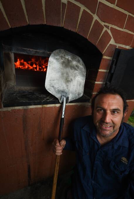 FIRE: Wood-fire oven coordinator Michael Laubli warming up the coals.