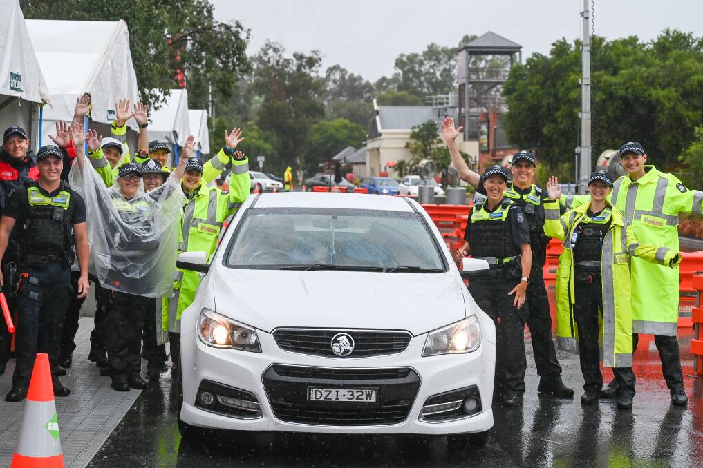 YAY: Victoria Police celebrate as the last car travels through the checkpoint though neither the government nor police made any announcement. Picture: MARK JESSER