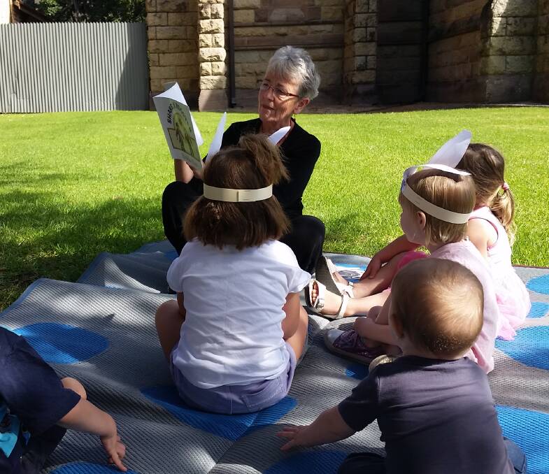 COMMUNITY HERO: MAMA volunteer and Riverina Volunteer of the Year, Kay Locke, reading to children at QEII square in Albury. Picture: SUPPLIED