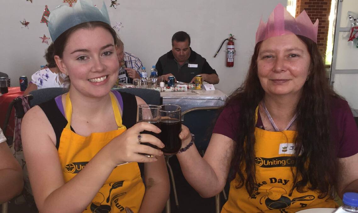 CHEERS: Wangaratta's Uniting Church Christmas lunch volunteers Alana Hill and Jen Thorsen enjoy a bite to eat in in 2015. 