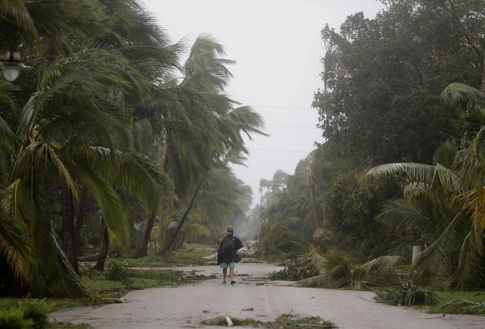 A person walks through a street lined with debris and fallen trees as Hurricane Irma passes through Naples, Fla., Sunday, Sept. 10, 2017. PICTURE:AP/David Goldman