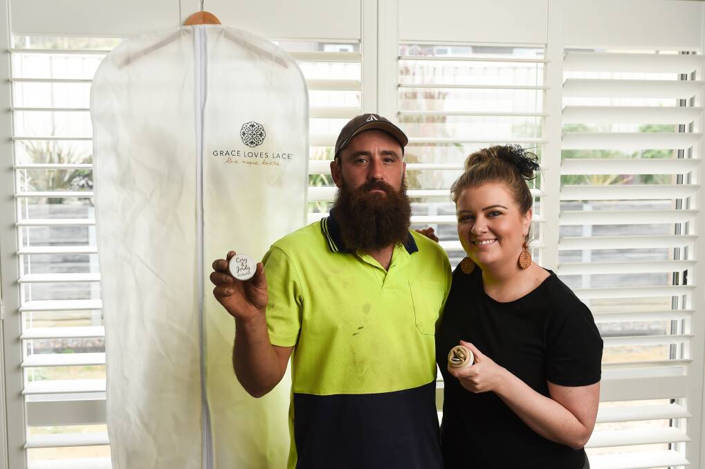 POSTPONED: Cory Hammans and Jordan Greenway, of Wodonga, with their wedding rings and ring box inscribed with their planned wedding date. Picture: MARK JESSER 
