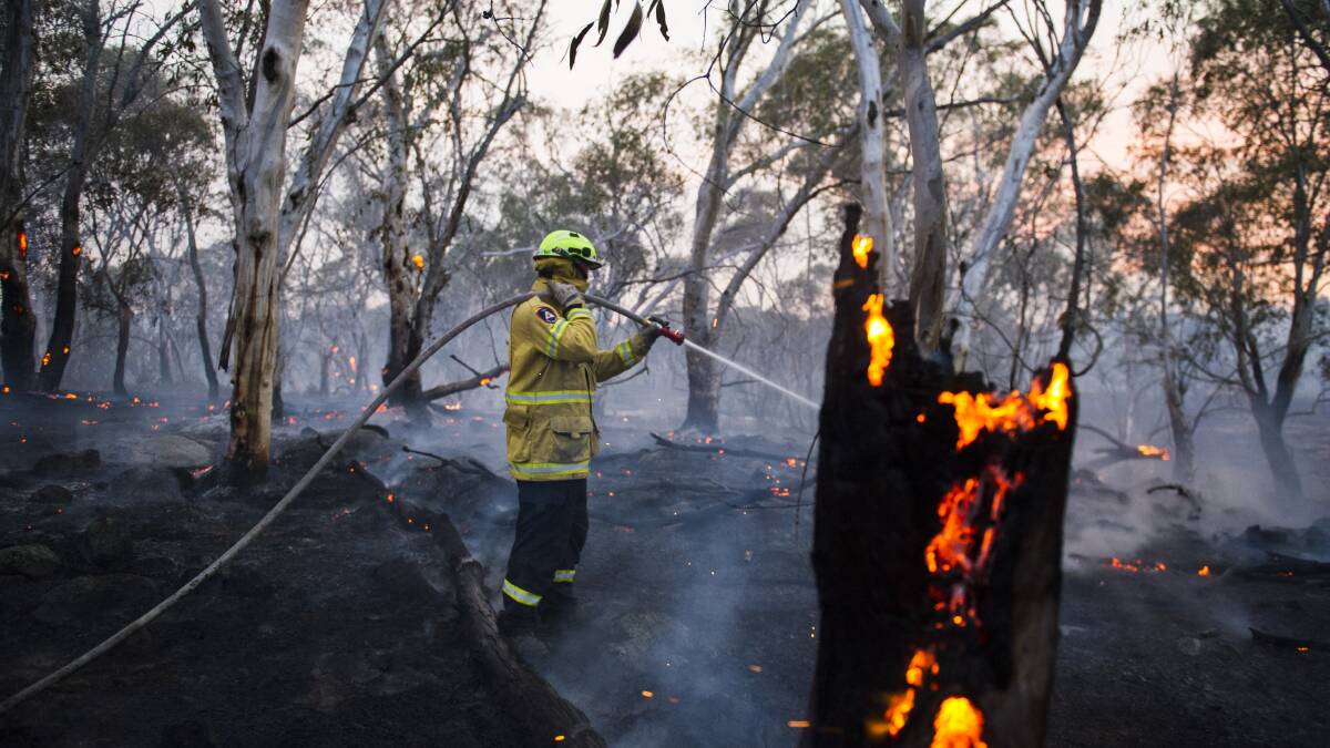 Firefighters work to put out fires at the edge of the NSW North Black Range bushfire. Picture: Dion Georgopoulos/Canberra Times