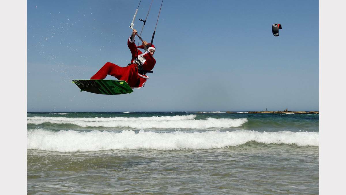 Kite-surfing Santas at Nobbys Beach, Newcastle. Photo: JONATHAN CARROLL