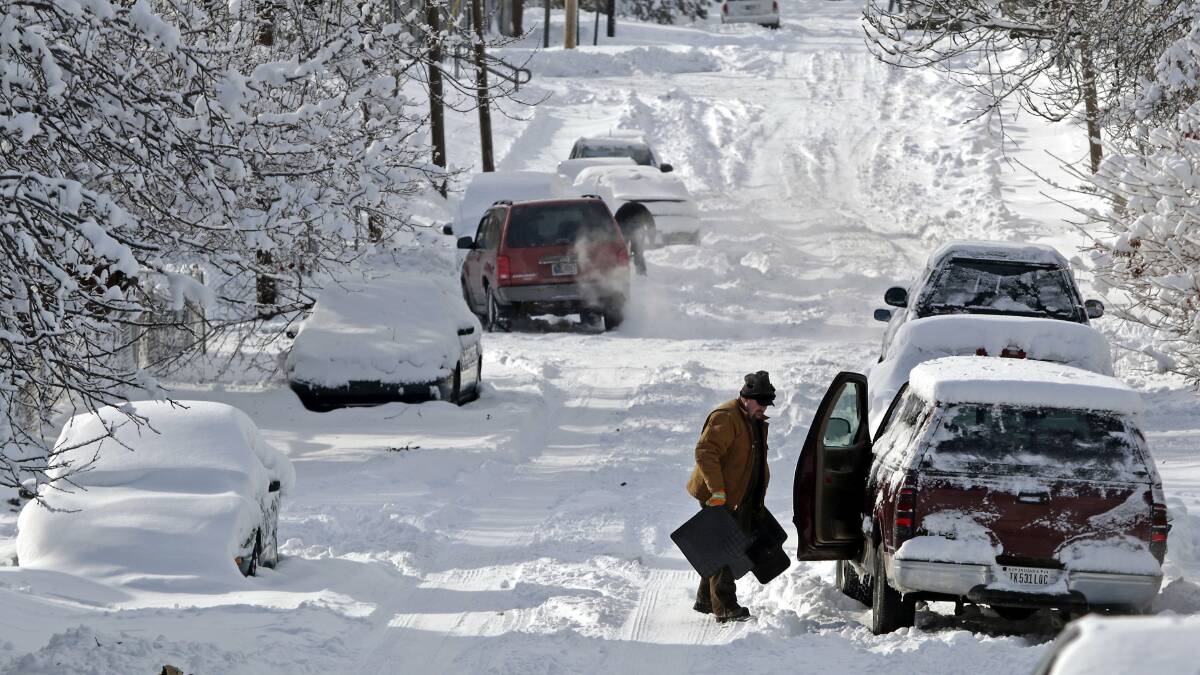 A man clears snow from his car in Indianapolis, Indiana January 6, 2014. Photo: REUTERS/Nate Chute.