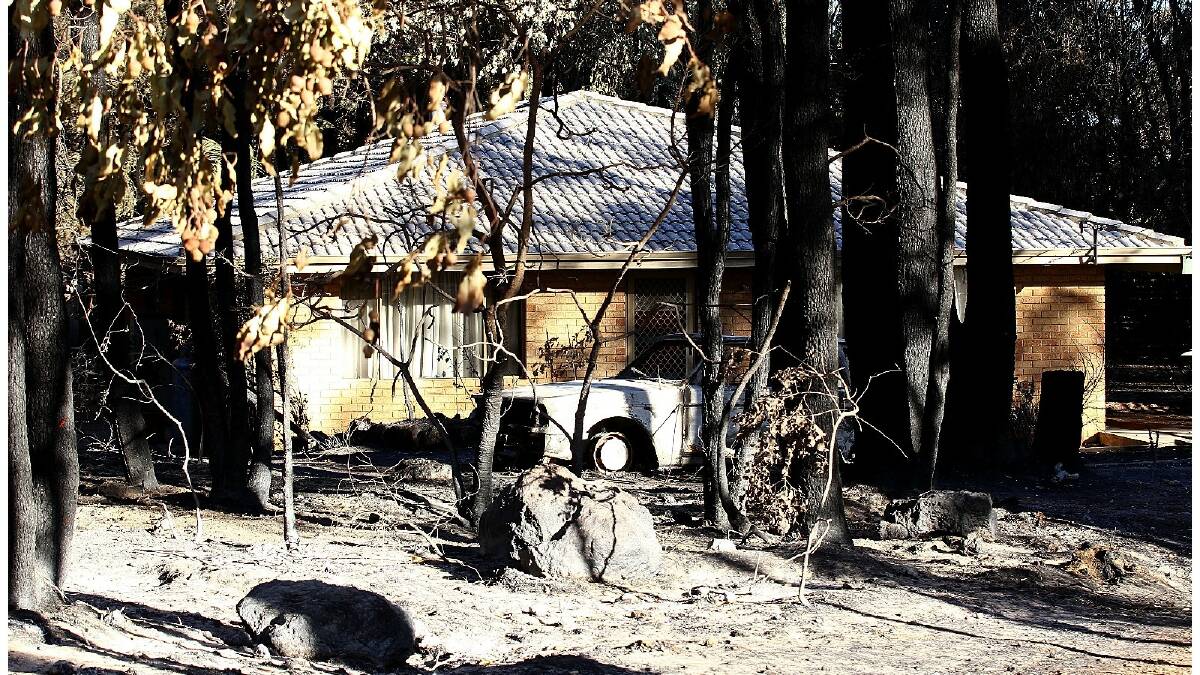 Emergency services escorted residents to survey damage to their homes and properties yesterday following a bushfire that destroyed more than 50 houses. Photo: Paul Kane/Getty Images.