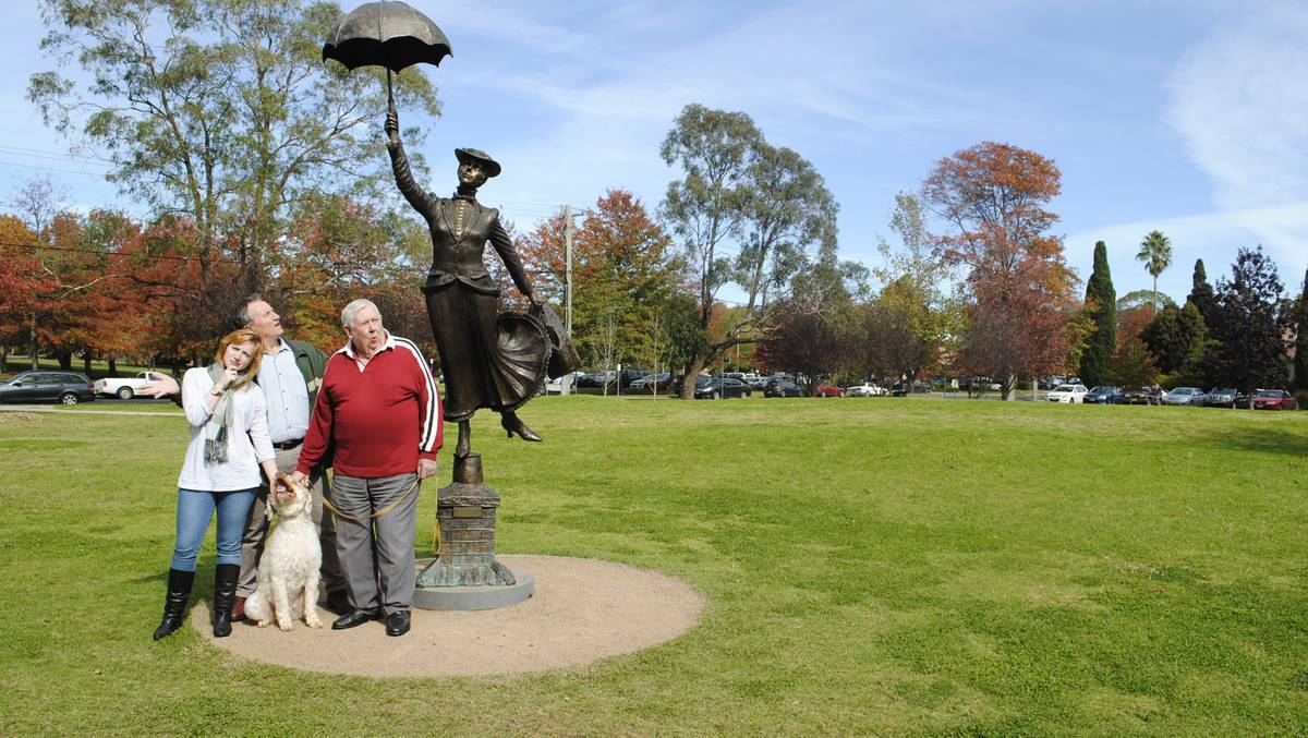 BOWRAL: There's something about Mary... and a spoon full of sugar won't fix it. The Mary Poppins statue in Bowral has changed direction. Pictured are Melissa and Paul McShane with Terry Oakes-Ash and his pet dog George, who first noticed something was amiss with Mary. Photo: DOMINICA SANDA, Southern Highland News.