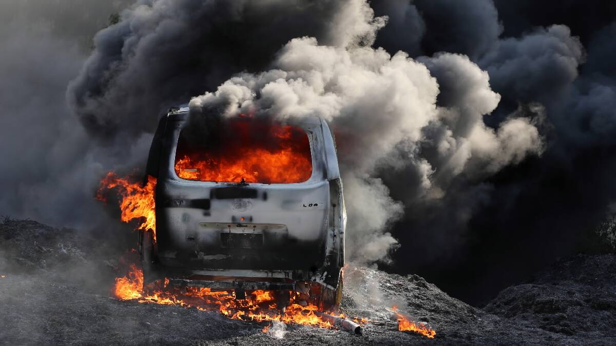 The van, stolen from Elgin Boulevard, burns fiercely off Sangsters Road. The intensity of the fires turned the black van white. Pictures: JOHN RUSSELL and MARK JESSER