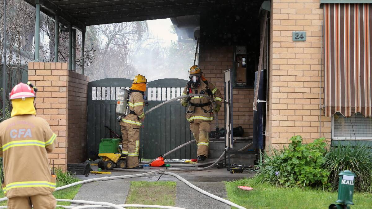Firefighters go about their tasks at a house fire at Wornes Drive, Wodonga, last August. 