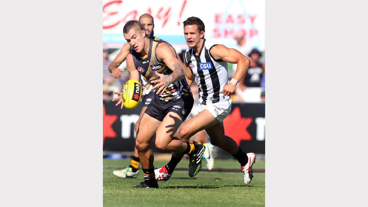 Dustin Martin swoops on the ball with Luke Ball close behind.