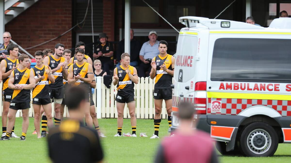 Tigers teammates applaud McQuillan as he is taken away by ambulance. Pictures: MATTHEW SMITHWICK