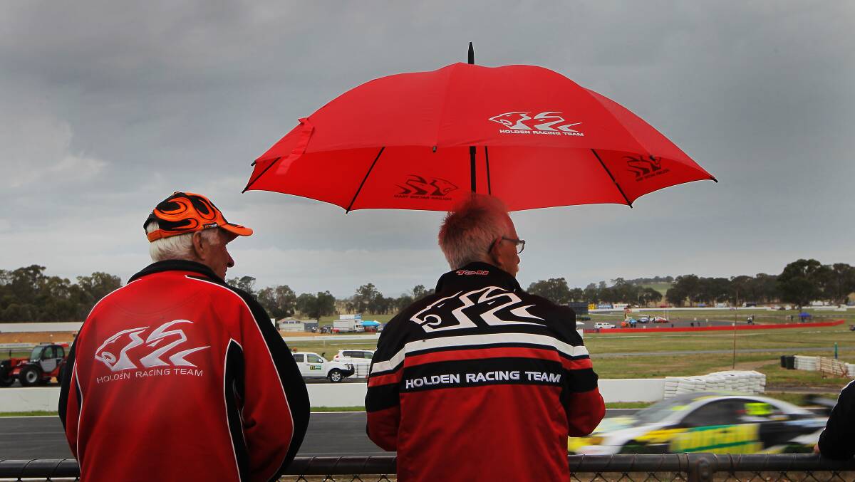  Holden fans John Steele and Terry Norris watch on in wet conditions.