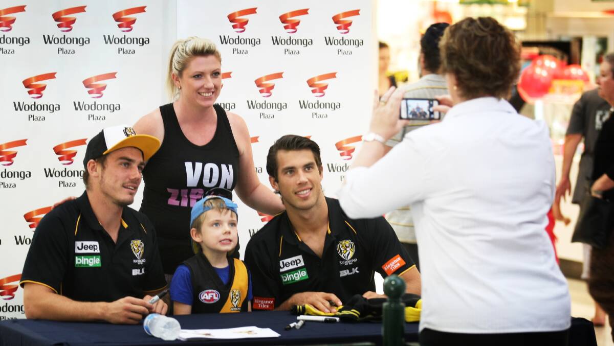 Baranduda's Archie Jackson, 4, and his mum Adelle pose for photos with Richmond players Brad Helbig and Alex Rance.