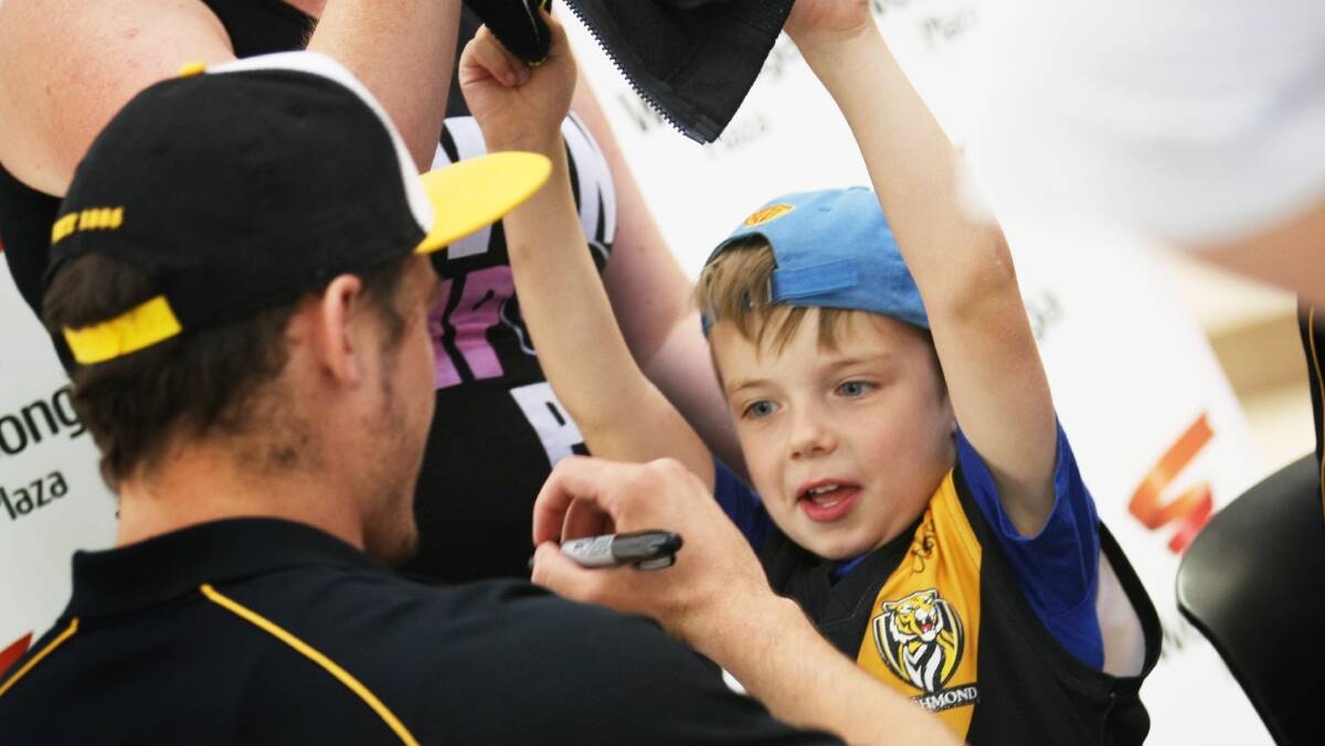 Richmond players Brad Helbig and Alex Rance give an autograph to Baranduda's Archie Jackson, 4, at the Wodonga Plaza. Picture: DYLAN ROBINSON