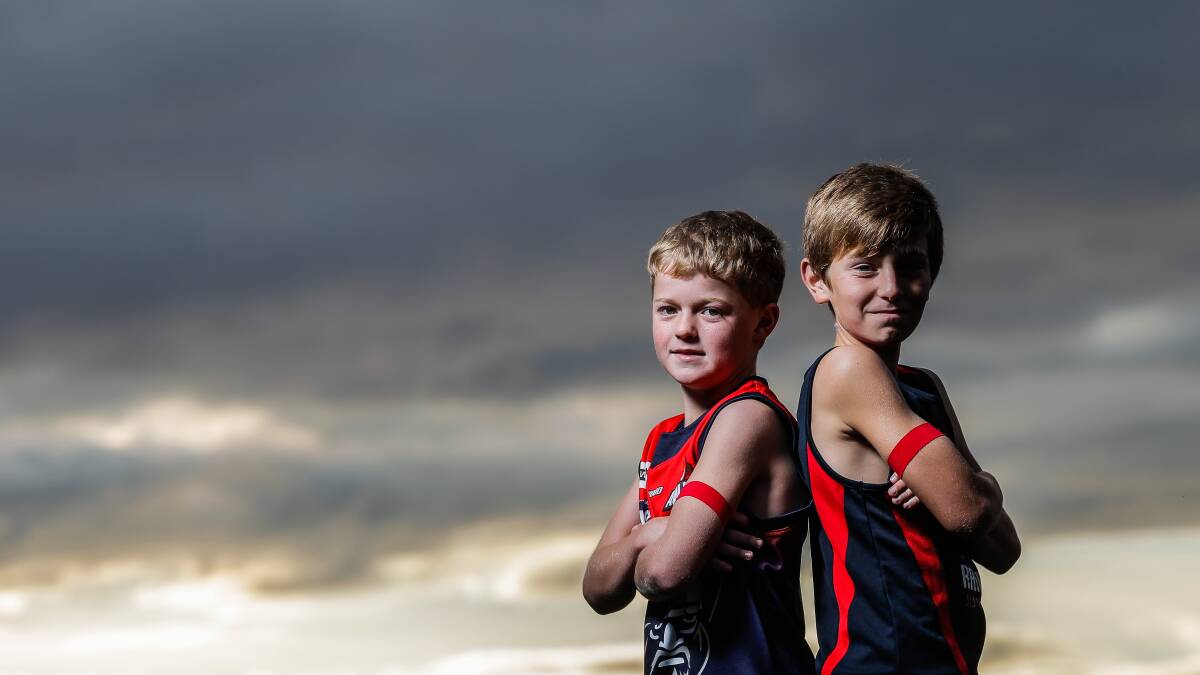 Junior under 12s player Max Beattie and Auskick player Finn Kernaghan with red arm bands for Cystic Fibrosis. Picture: DYLAN ROBINSON