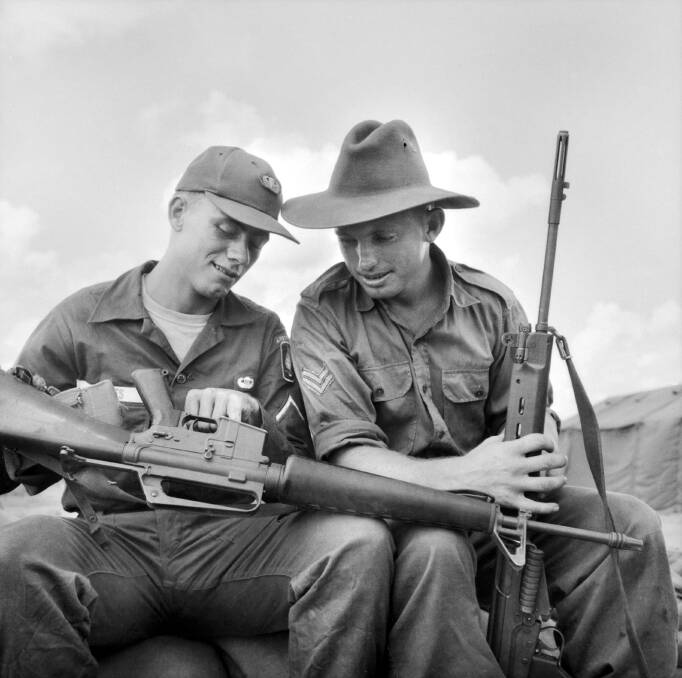 The then Corporal Jeff Taylor (right) watches while Private First Class Tom Hughes, of the 173rd US Airborne Brigade, explains the operation of the US Armalite rifle. Picture: DNE/65/0072/VN — AUSTRALIAN WAR MEMORIAL