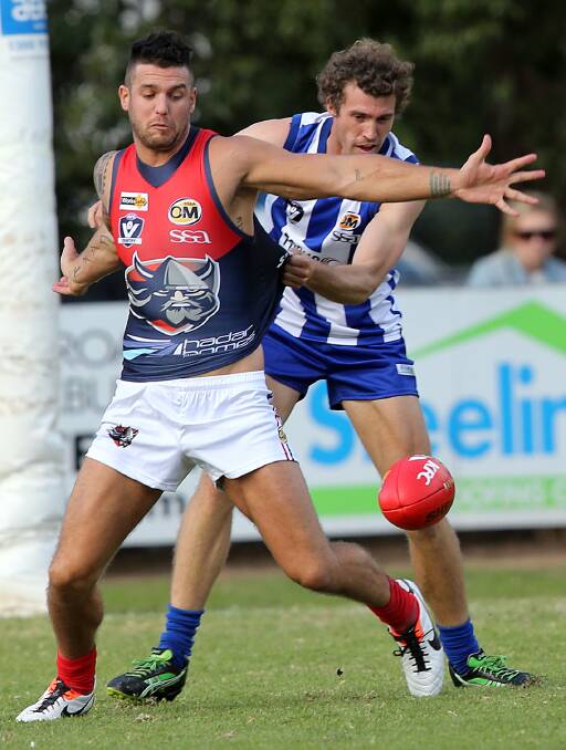 Wodonga Raiders star Dean Limbach, who kicked seven goals, is held by Roo Al Austin. 