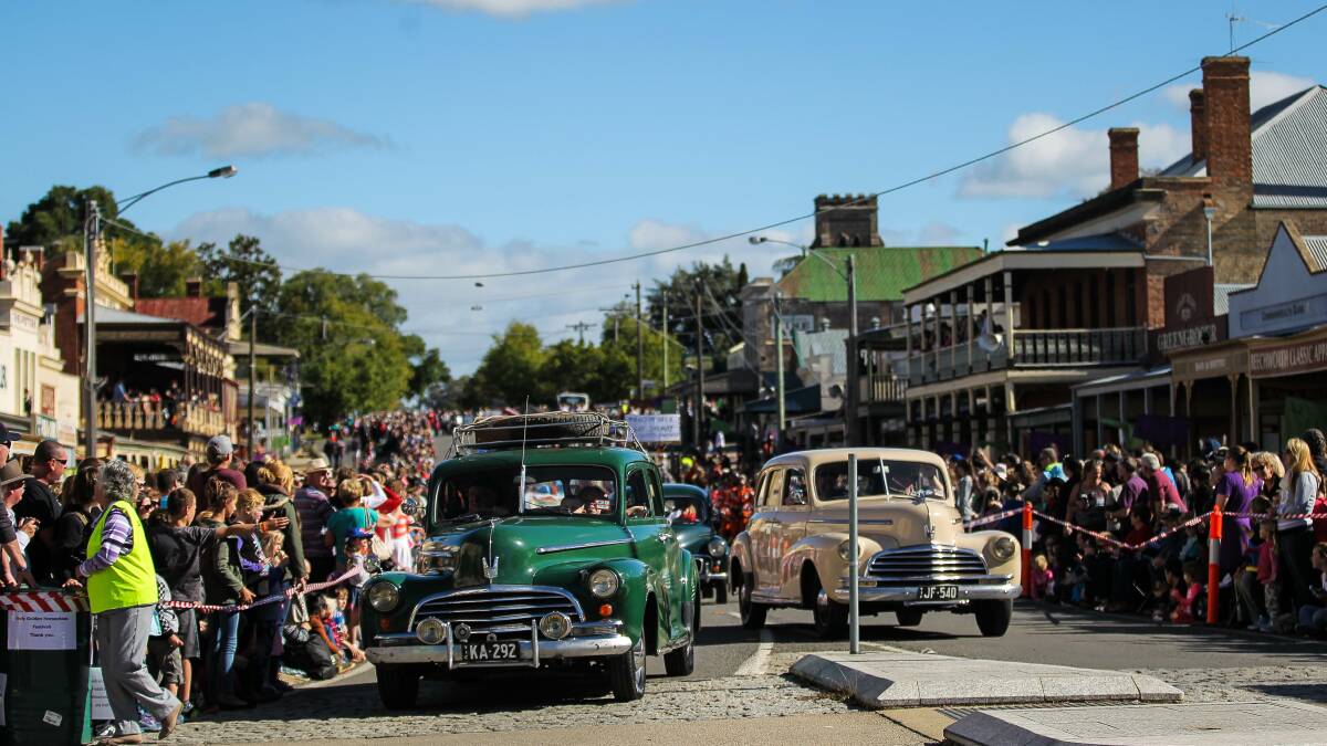 Vintage cars parade down Ford Street. 