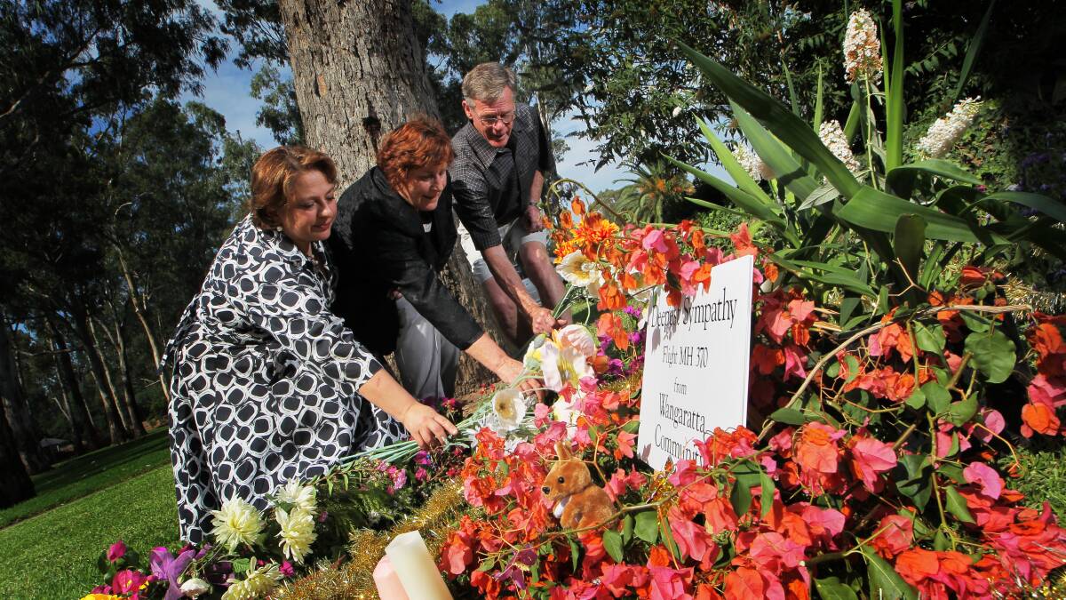 Former member for Indi Sophie Mirabella places flowers on a tribute to the missing passengers from Malaysia Airlines Flight MH370 with Wangaratta residents Beryl Klemm and Allan Wilson. Picture: DYLAN ROBINSON
