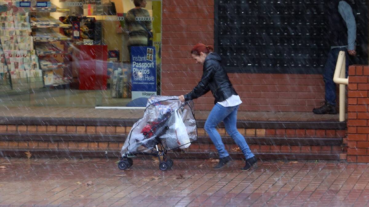 A woman races to escape the rain in High Street, Wodonga, yesterday. Picture: PETER MERKESTEYN