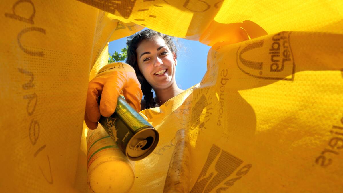 Laura Dingle, 16 of Thurgoona places some rubbish into a bag on Clean Up Australia Day. 
