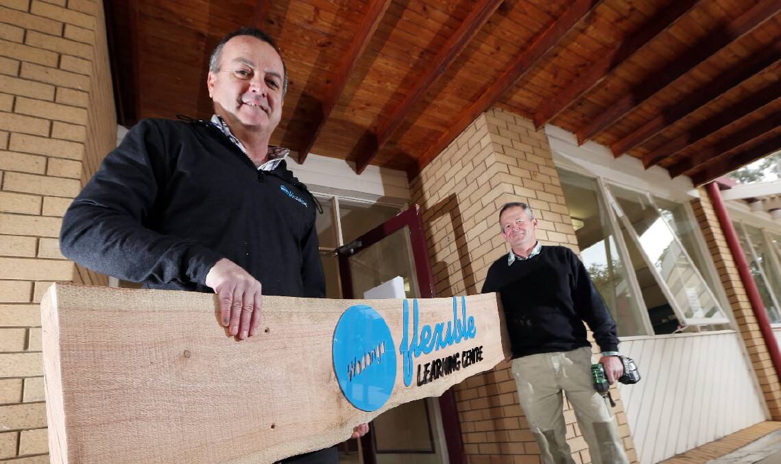 Wodonga Flexible Learning Centre Campus Principal Huw Derwentsmith and Garry Gibson hold the sign designed and built by students at the new campus, formerly Belvoir Special School in Wodonga. Picture: JOHN RUSSELL