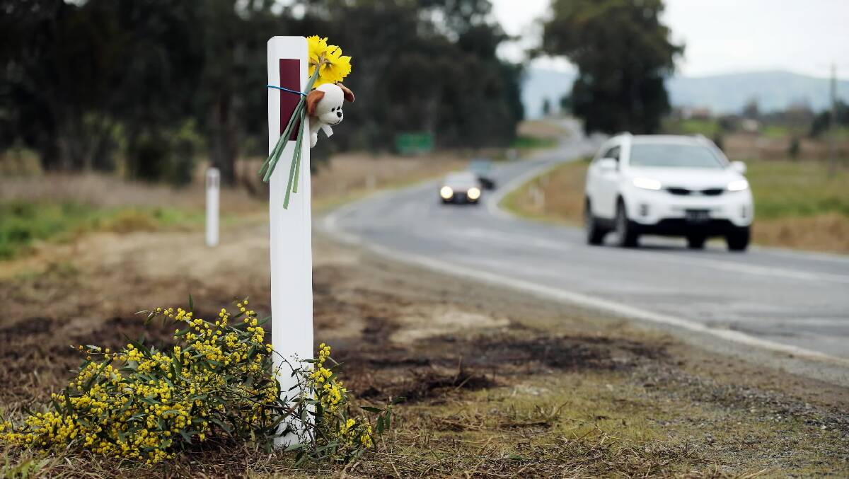 Daffodils, wattle and a teddy have been left at the site of Thursday's triple fatality crash at Staghorn Flat. Picture: JOHN RUSSELL