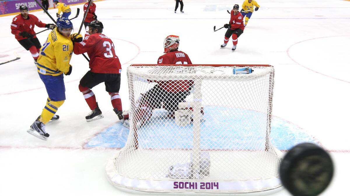 Daniel Alfredsson #11 of Sweden shoots and scores against Reto Berra #20 of Switzerland in the third period during the Men's Ice Hockey Preliminary Round Group C game on day seven of the Sochi 2014 Winter Olympics,.Russia. Photo by Bruce Bennett/Getty Images