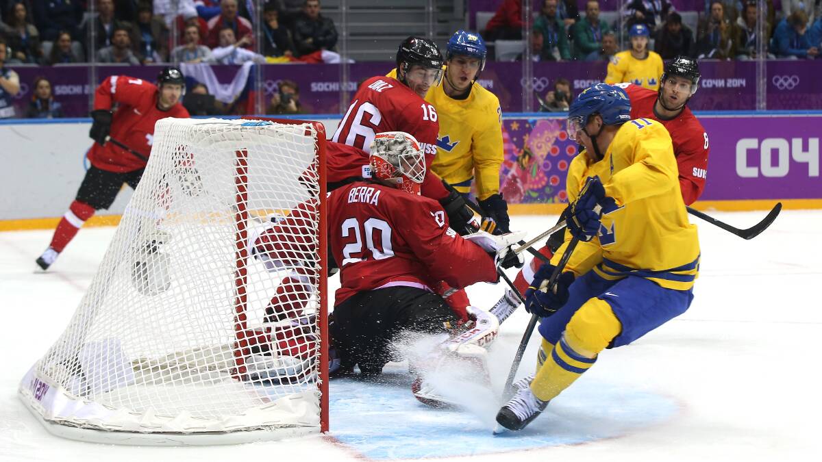 Daniel Alfredsson #11 of Sweden shoots and scores against Reto Berra #20 of Switzerland in the third period during the Men's Ice Hockey Preliminary Round Group C game on day seven of the Sochi 2014 Winter Olympics. Photo by Bruce Bennett/Getty Images
