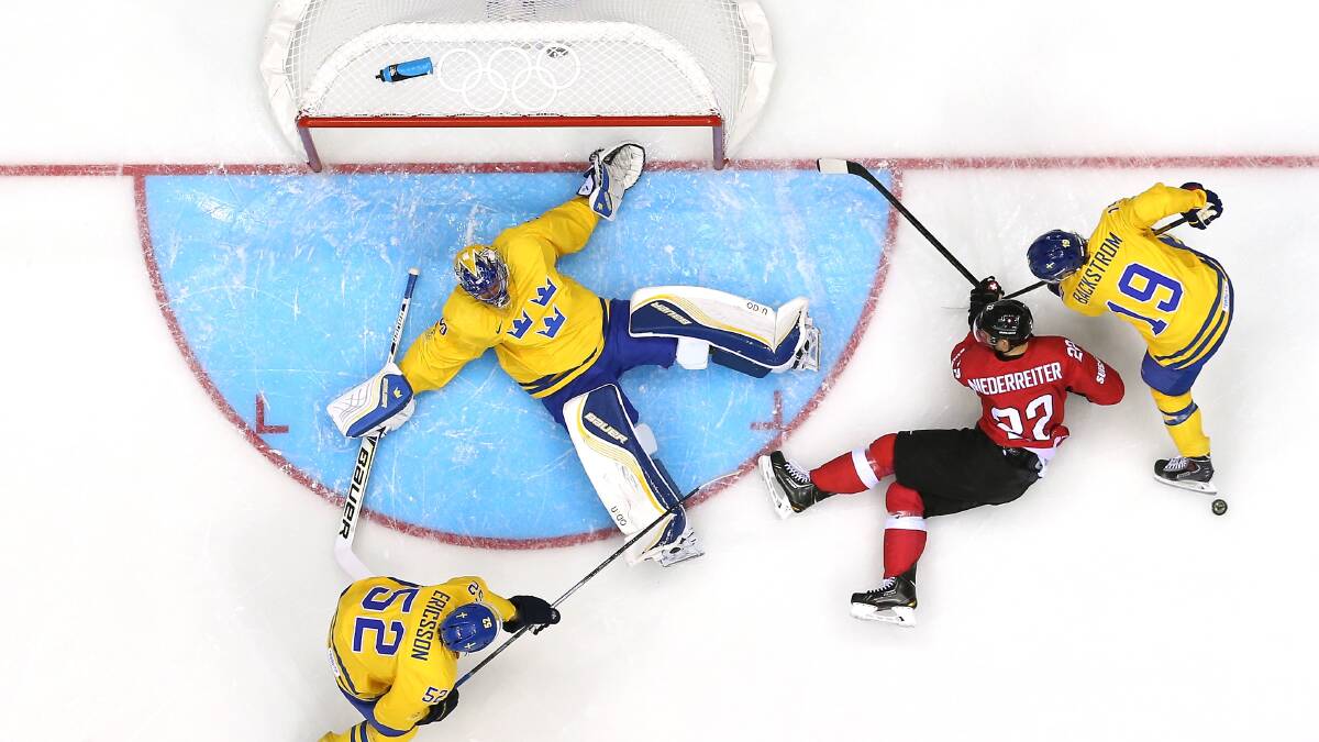 Henrik Lundqvist #30 of Sweden makes a save against Nino Niederreiter #22 of Switzerland in the first period during the Men's Ice Hockey Preliminary Round Group C game on day seven of the Sochi 2014 Winter Olympics at Bolshoy Ice Dome. Photo by Bruce Bennett/Getty Images