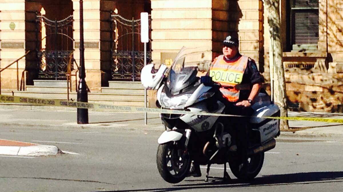 Armed police await the emergence of fugitive Rodney Clavell, who is holed up in a building in the Adelaide CBD.