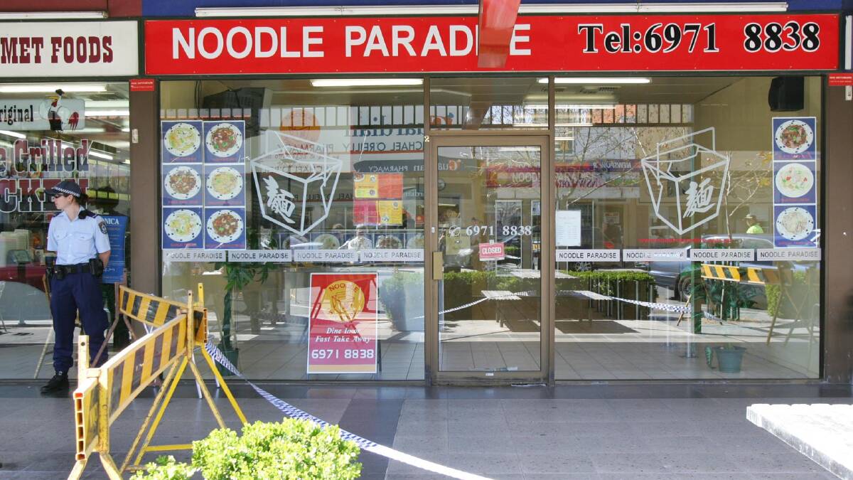 A policeman guards the Noodle Paradise store after the discovery of Deng Cheng Li's body in 2006. Picture: Les Smith