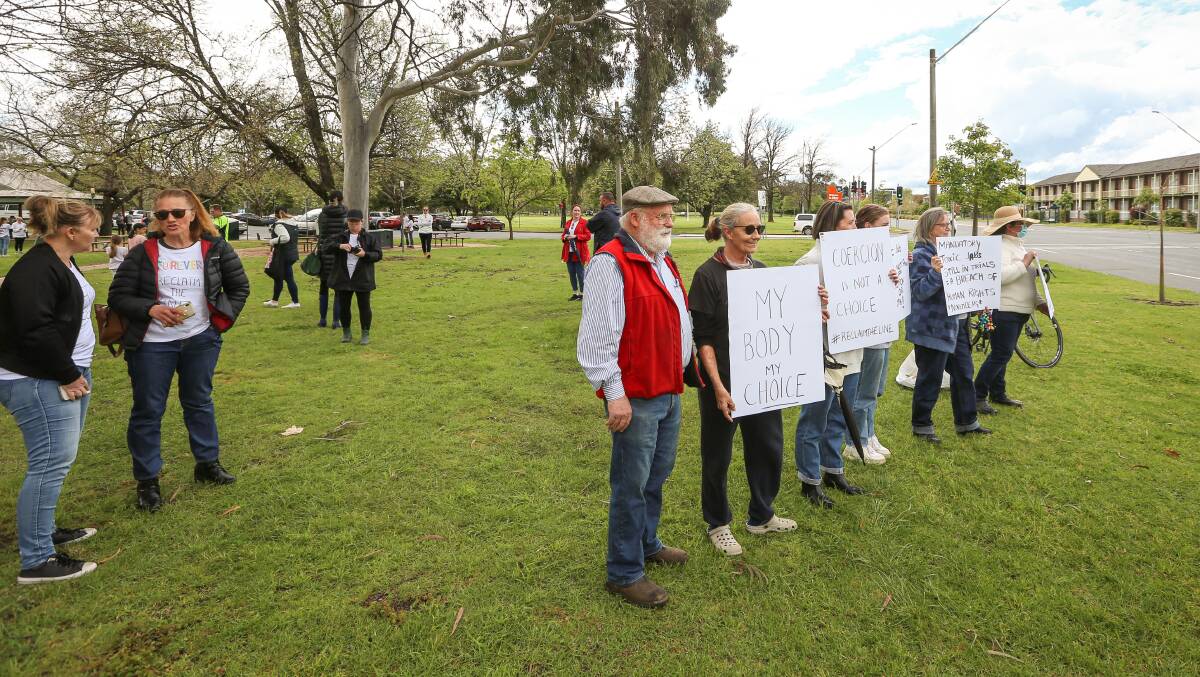 GATHERING: About 200 people, including those with signs, attended Friday's protest against mandatory vaccinations for workers at Albury's Australia Park. Picture: JAMES WILTSHIRE