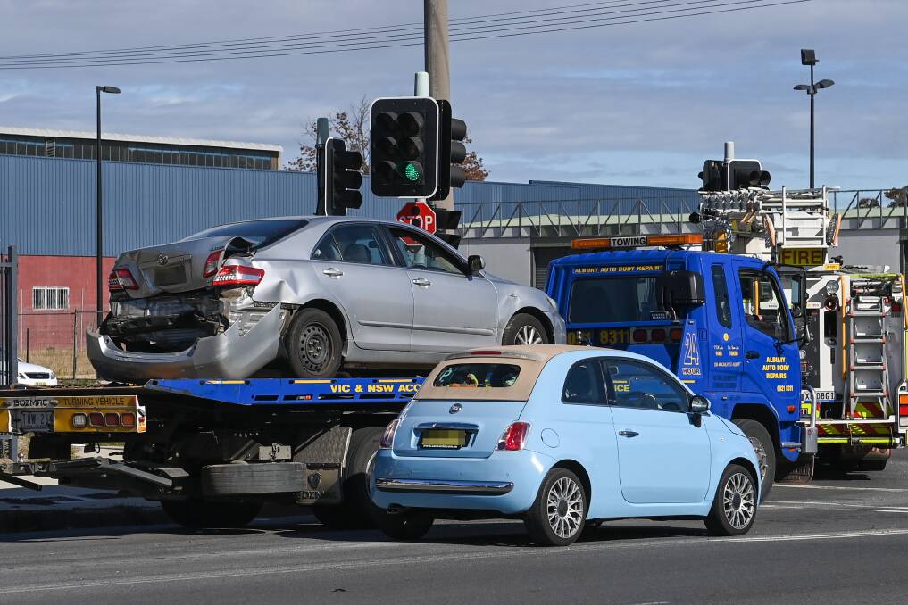 TOWED: A silver Toyota Camry is removed from the crash site after sustaining damage to the rear of the vehicle. A woman was also hospitalised. Picture: MARK JESSER