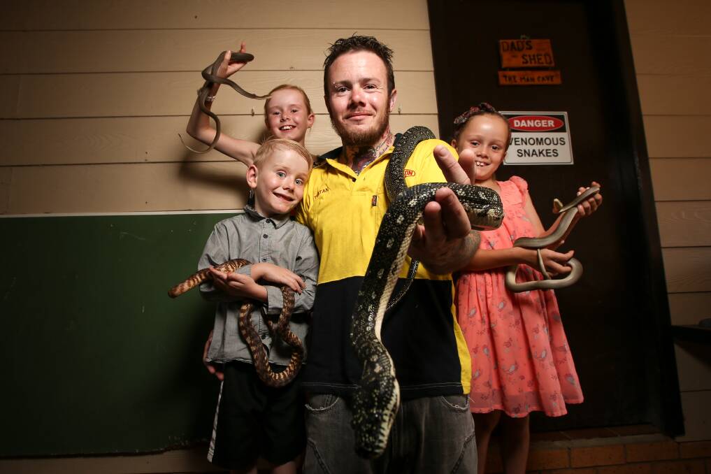 SNAKE MAN: Tristan Hamilton and his children Seth, Olivia and Aaliah and their pet pythons. The Wodonga man is getting called to three jobs a day for people who discover snakes on their property and need help removing them. Picture: JAMES WILTSHIRE