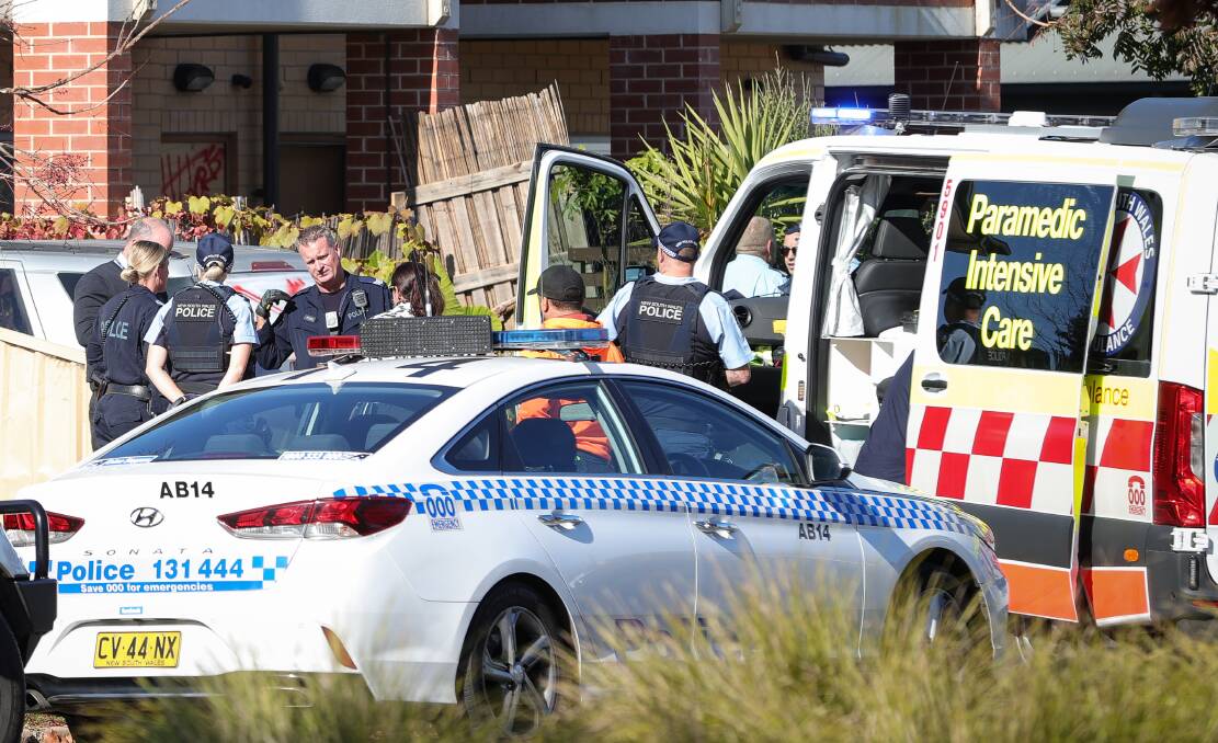 TREATMENT: Paramedics with police outside the unit. Picture: JAMES WILTSHIRE