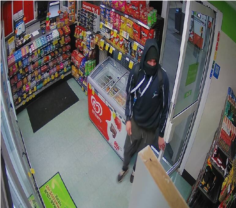 WANTED: An image from a security camera at the Woolworths petrol station. Police are trying to identify the armed robber, who had a knife and fled with cash. 