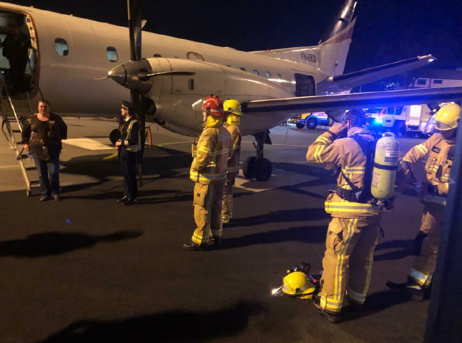 GROUNDED: Firefighters with the plane at Sydney Airport. 