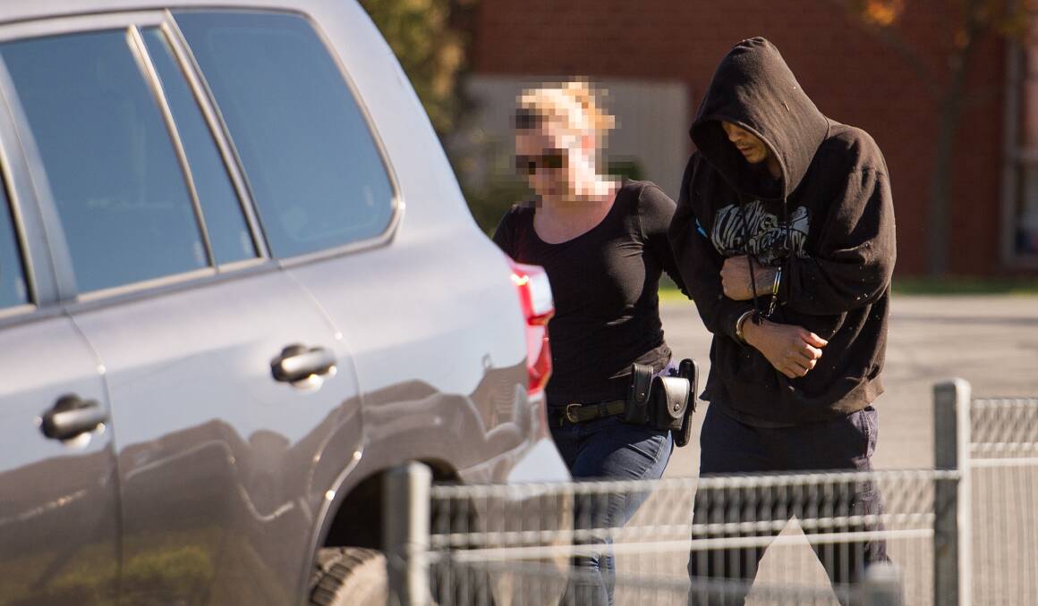 ARRESTED: A detective removes a 42-year-old man from the Wodonga home on Wednesday. He had not been charged. Police from the Clandestine Laboratory Squad also searched the house. Picture: MARK JESSER