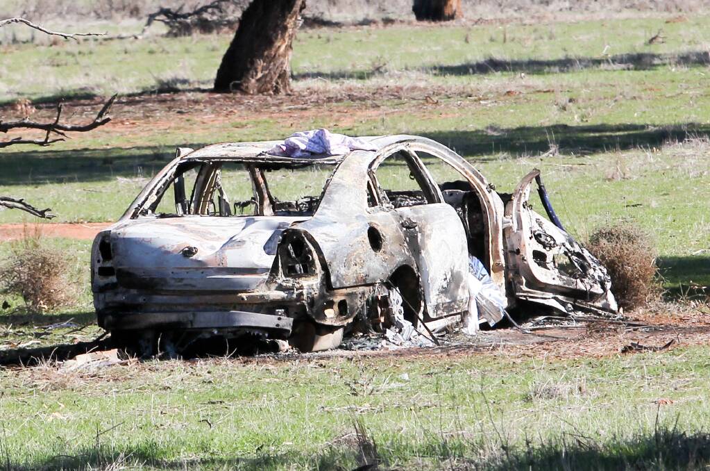 DAMAGED: The crashed Holden Commodore caught alight. 