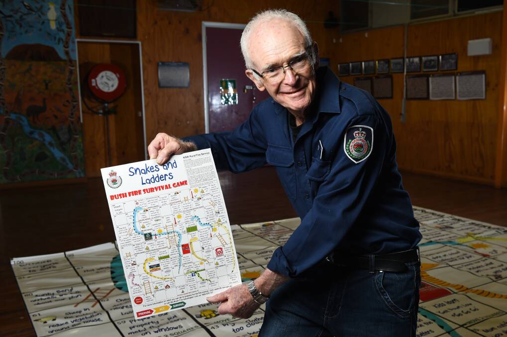 EDUCATION: Peter Farry with his snakes and ladders game, which is used to raise awareness of fire danger. 